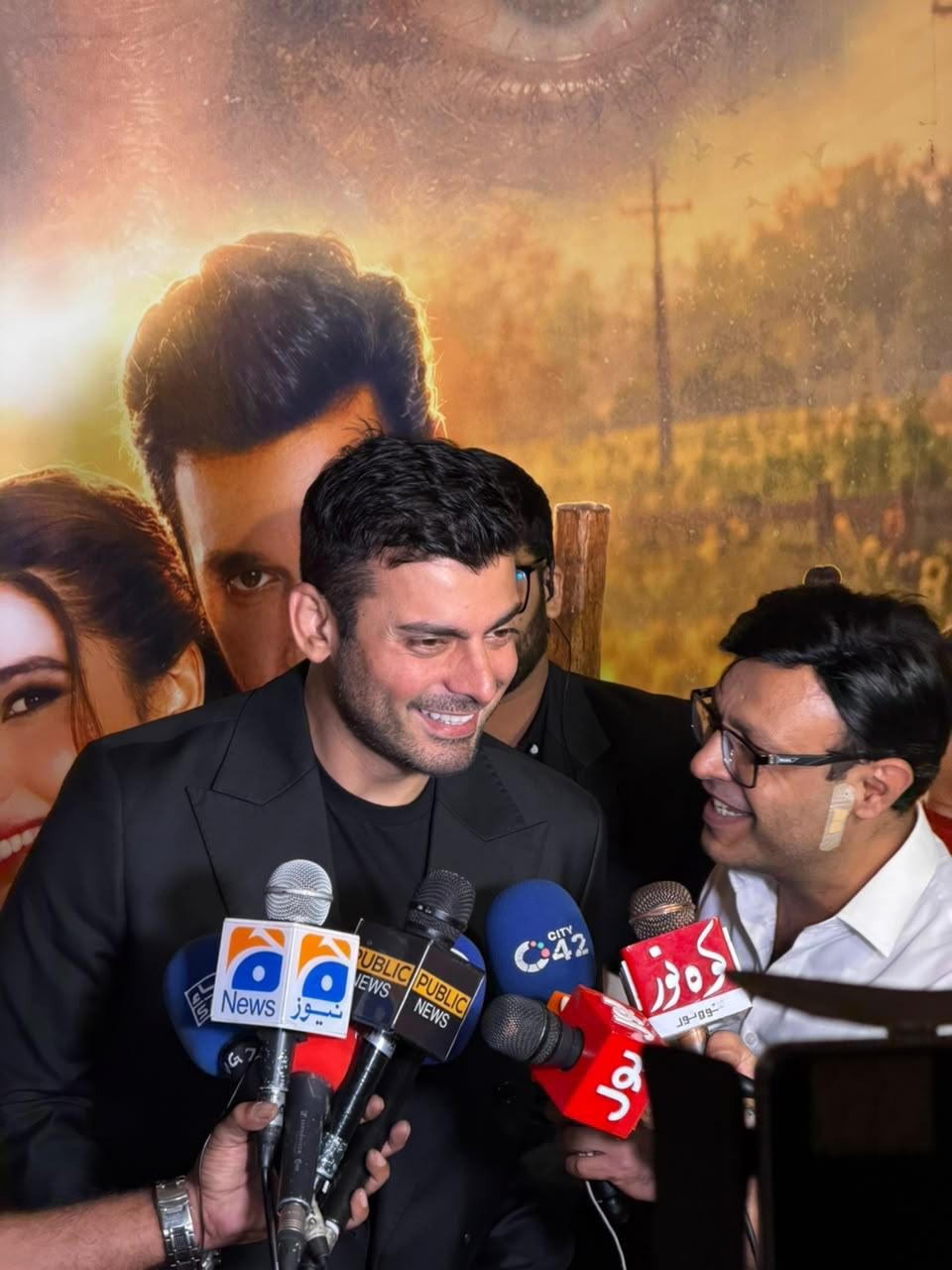 A lead actor speaking into Geo, City 42 and Dunya microphones at the premiere